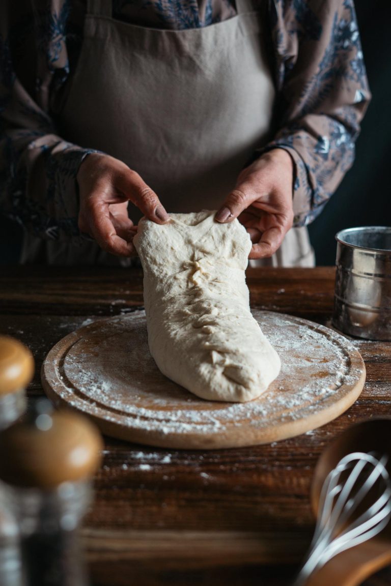 Hands kneading dough in a rustic kitchen, ideal for culinary themes.
