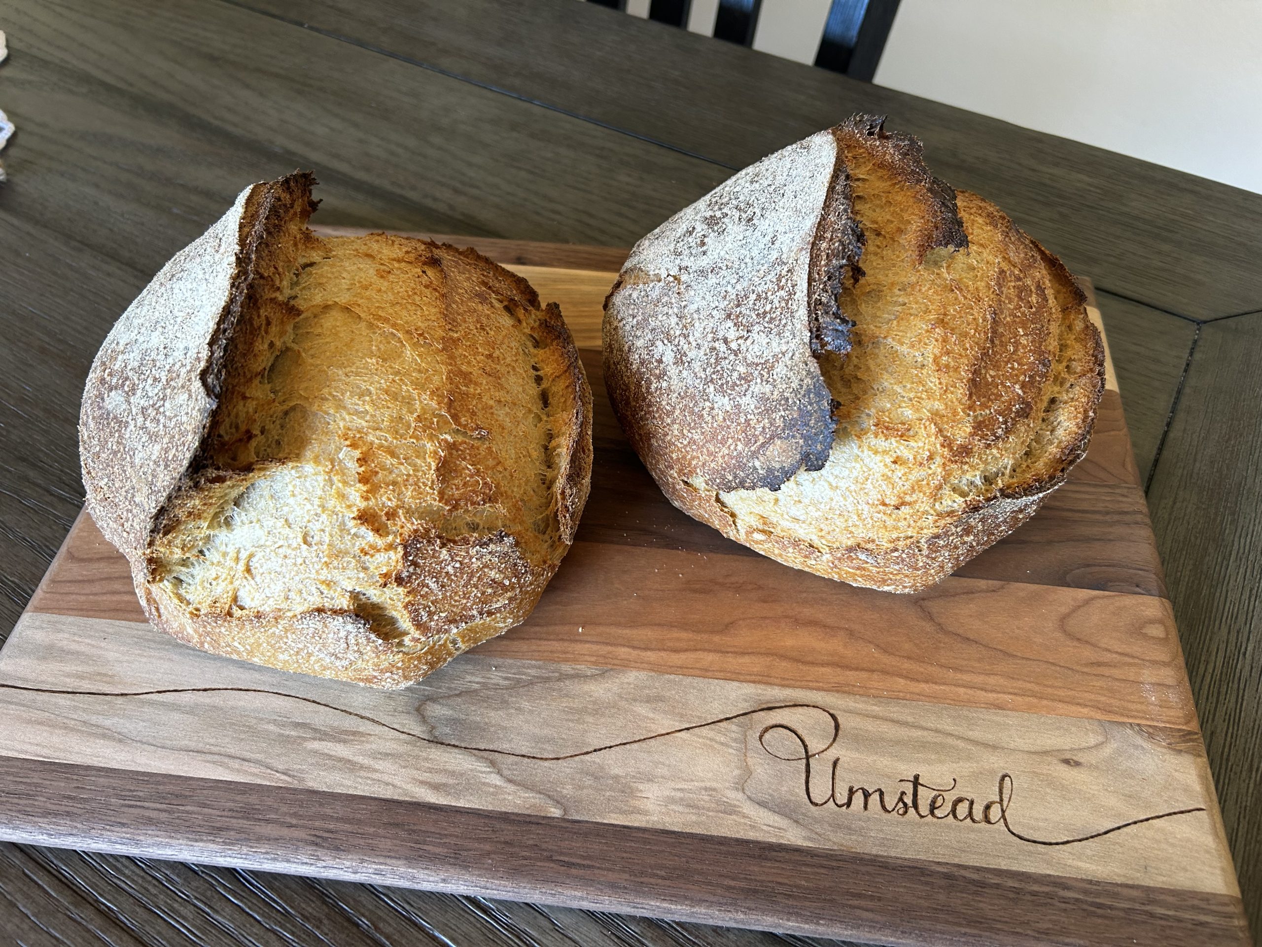 Two sourdough boules made with fresh-milled flour on a cutting board