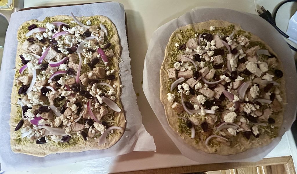 Fresh-milled chicken pesto pizzas ready to go into the oven