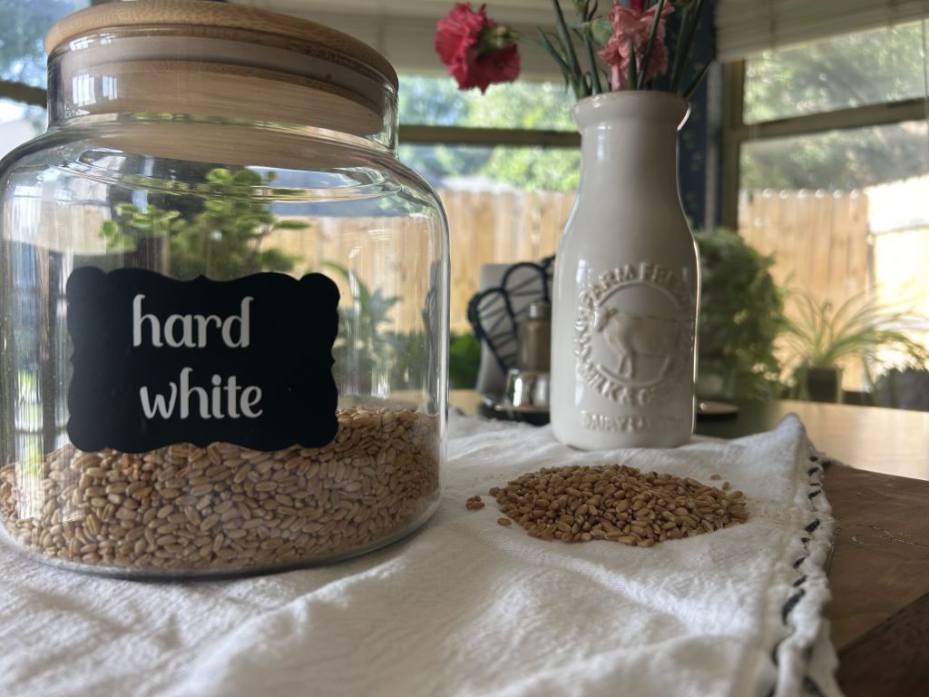 Jar of hard white grain on a white cloth over a cutting board